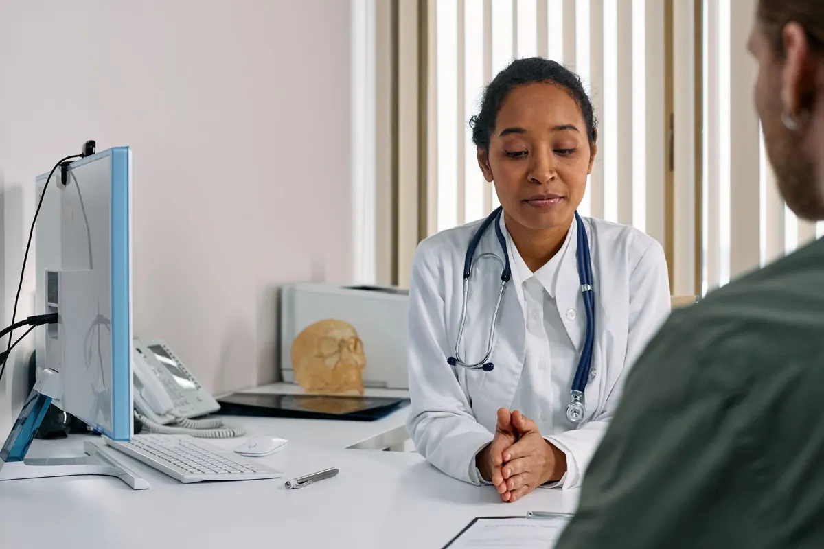 Médica em consulta com um paciente em um consultório