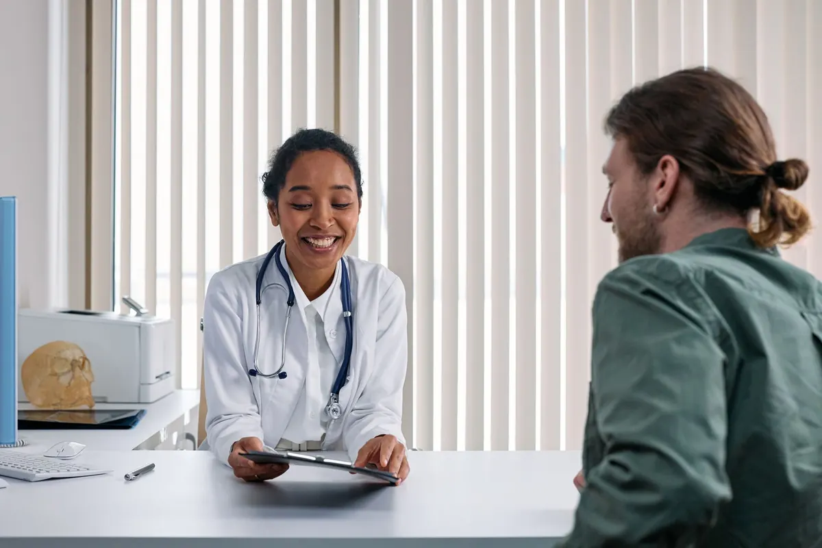 Médica atendendo um paciente em consultório